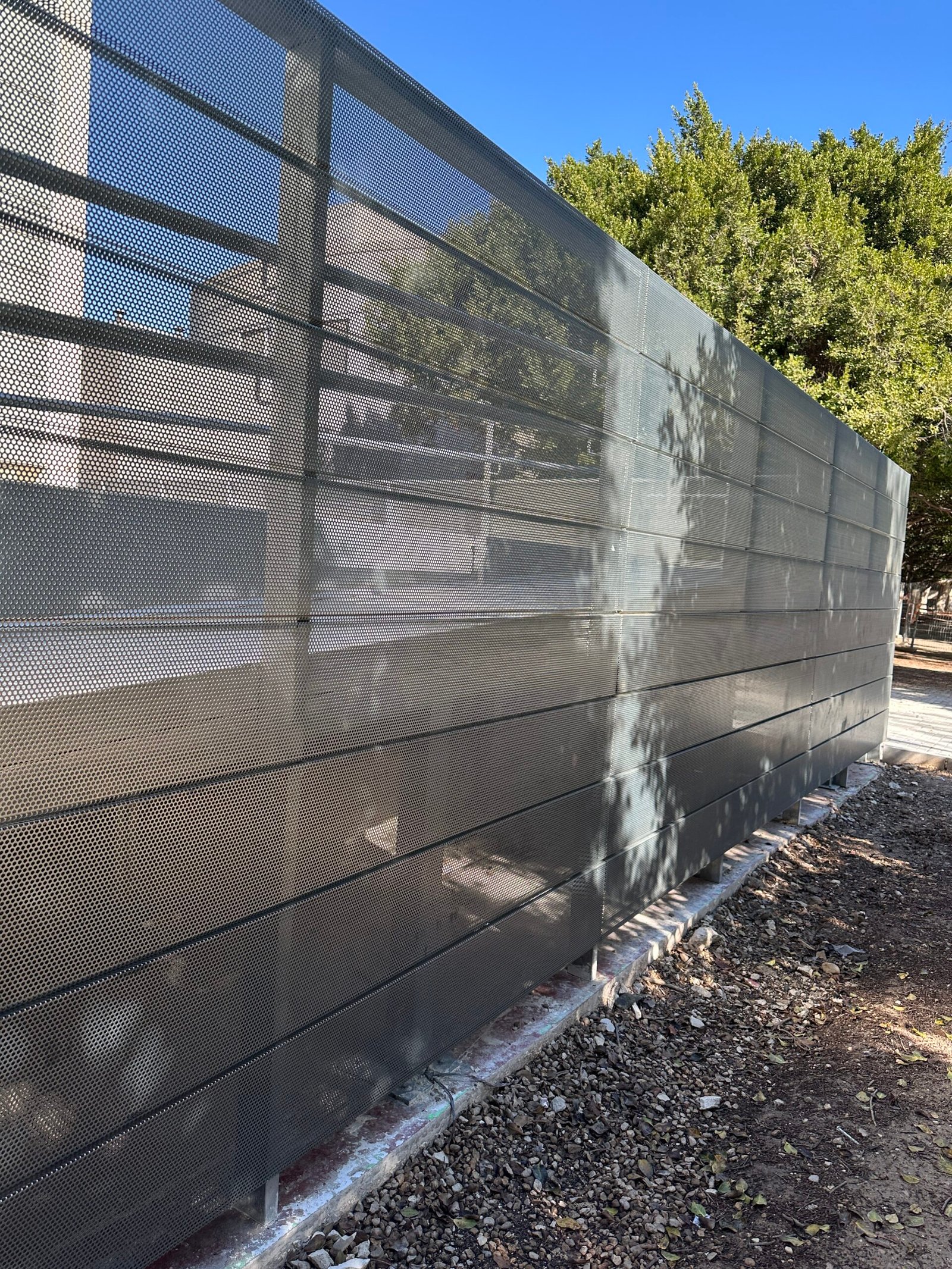 Cerramiento metálico perforado instalado por Puertas Metálicas del Mediterráneo