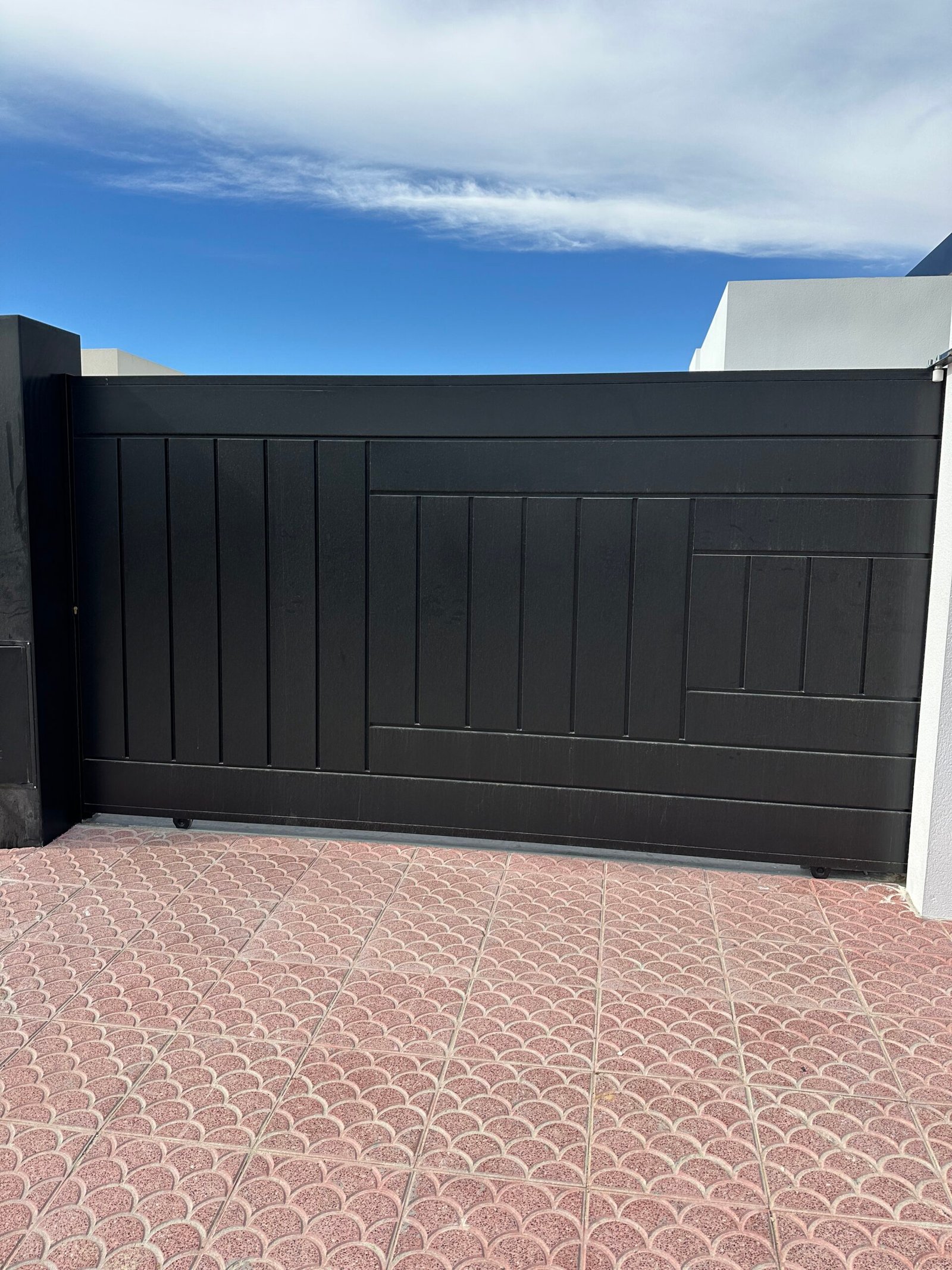 Puerta corredera metálica de color negro fabricada por Puertas Metálicas del Mediterráneo